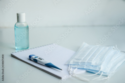 on a white table are a Notepad, medical masks, and antiseptic hand gel. to do list in case of illness