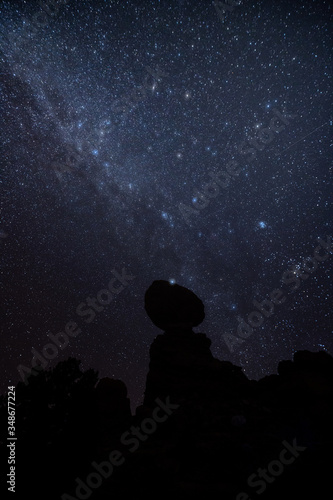 Night sky and Milky Way behind Balanced Rock at Arches National Park after sunset.