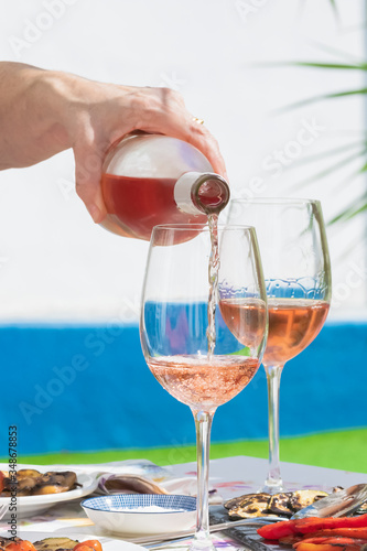 a hand of woman pouring rose wine