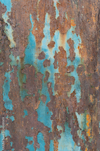 background of blue painted metal that is peeling away to expose the rusting surface beneath