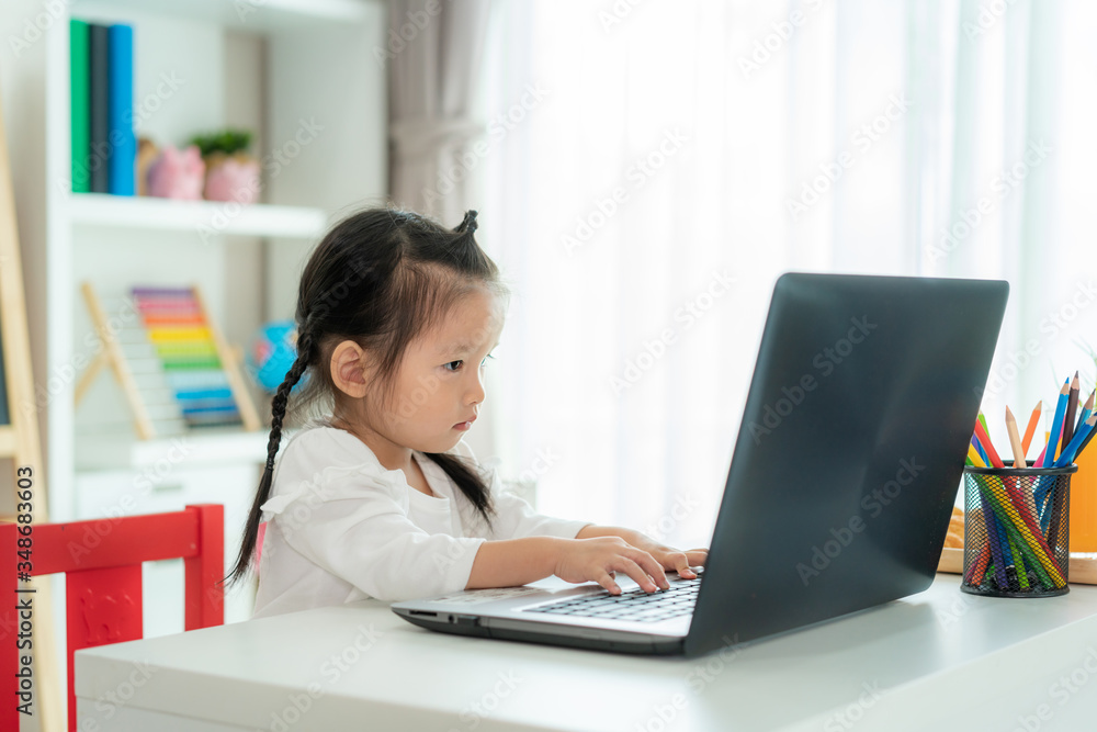 Asian kindergarten school girl video conference e-learning with teacher on laptop in living room at home. Homeschooling and distance learning ,online ,education protect from COVID-19 virus. Asian kindergarten school girl video conference e-learning with teacher on laptop in living room at home. Homeschooling and distance learning ,online ,education protect from COVID-19 virus.