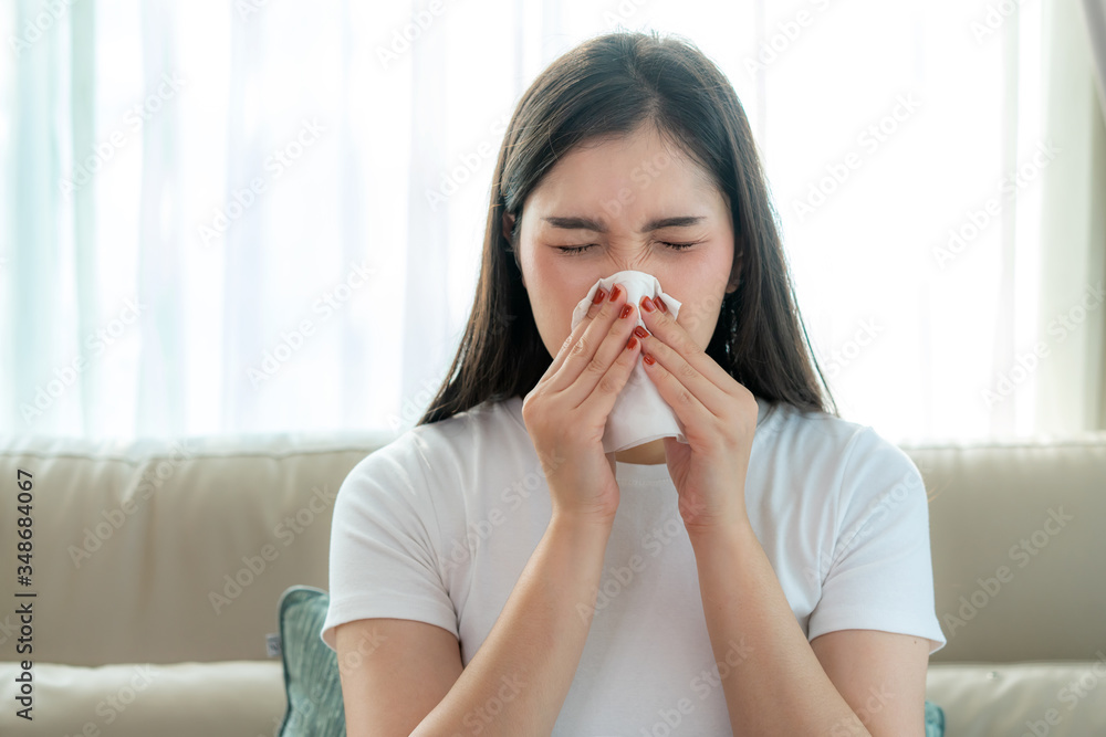 Asian woman sick and sad with sneezing on nose and cold cough on tissue paper because influenza and weak or virus bacteria from dust weather or smoke for medical.. Asian woman sick and sad with sneezing on nose and cold cough on tissue paper because influenza and weak or virus bacteria from dust weather or smoke for medical..