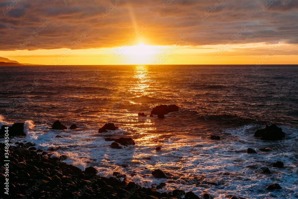Obraz premium Sunset over the ocean on a tropical island. Sunny evening on Tenerife Background color with gradient and grain, sound effect.