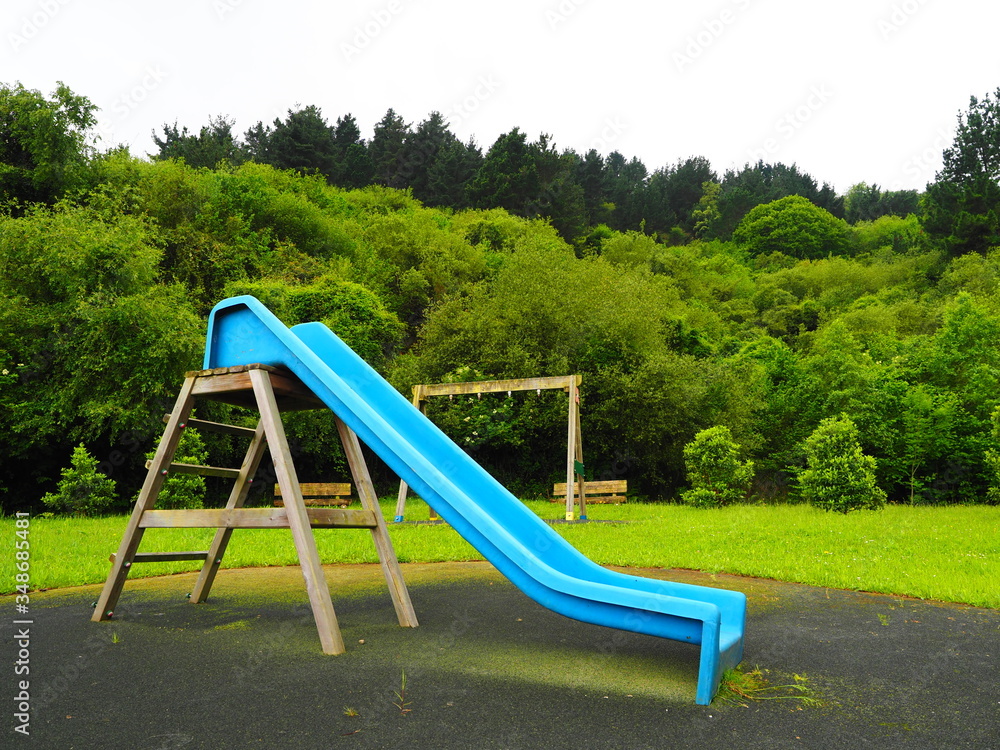 Fototapeta premium tobogan azul en un parque infantil en medio de la naturaleza
