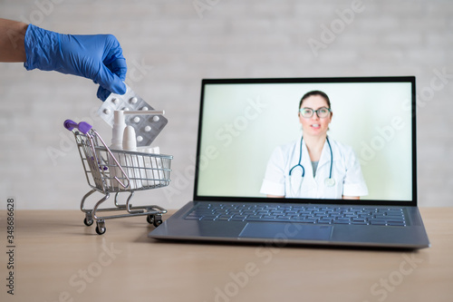 A friendly doctor gives a remote prescription on a laptop. The pharmacist adds a cure for the virus in the mini cart. Online medicine concept. Order drugs online. Video call.