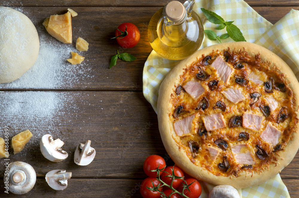 ham and mushroom pizza with ingredients on a wooden background ham and mushroom pizza with ingredients on a wooden background