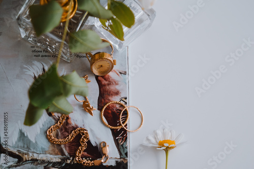 jewelry on a white background next to a flower delicious perfume