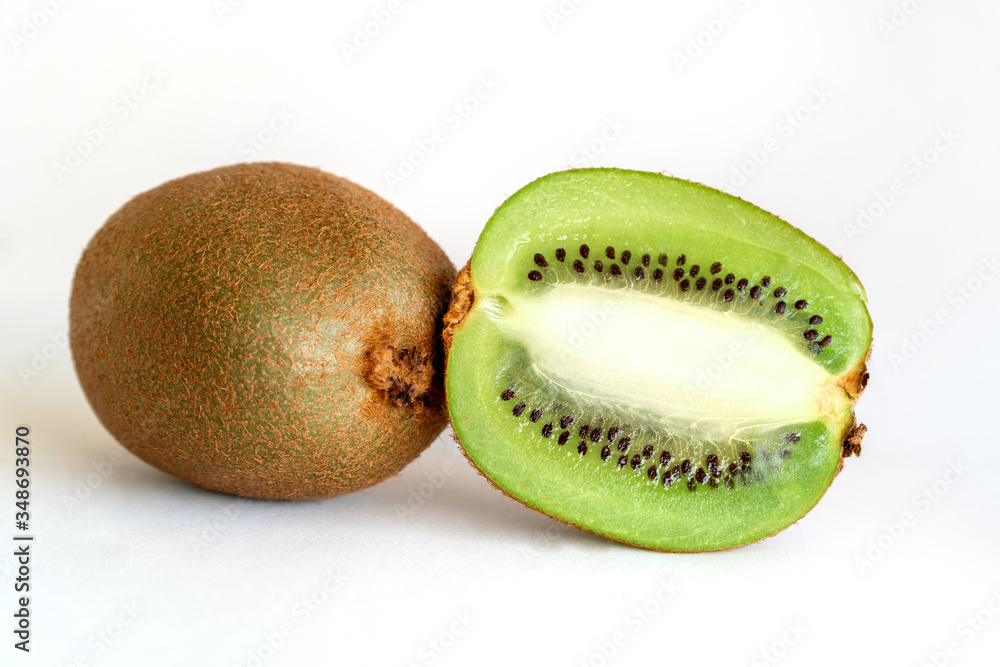 Whole and half-sliced kiwi on a white background