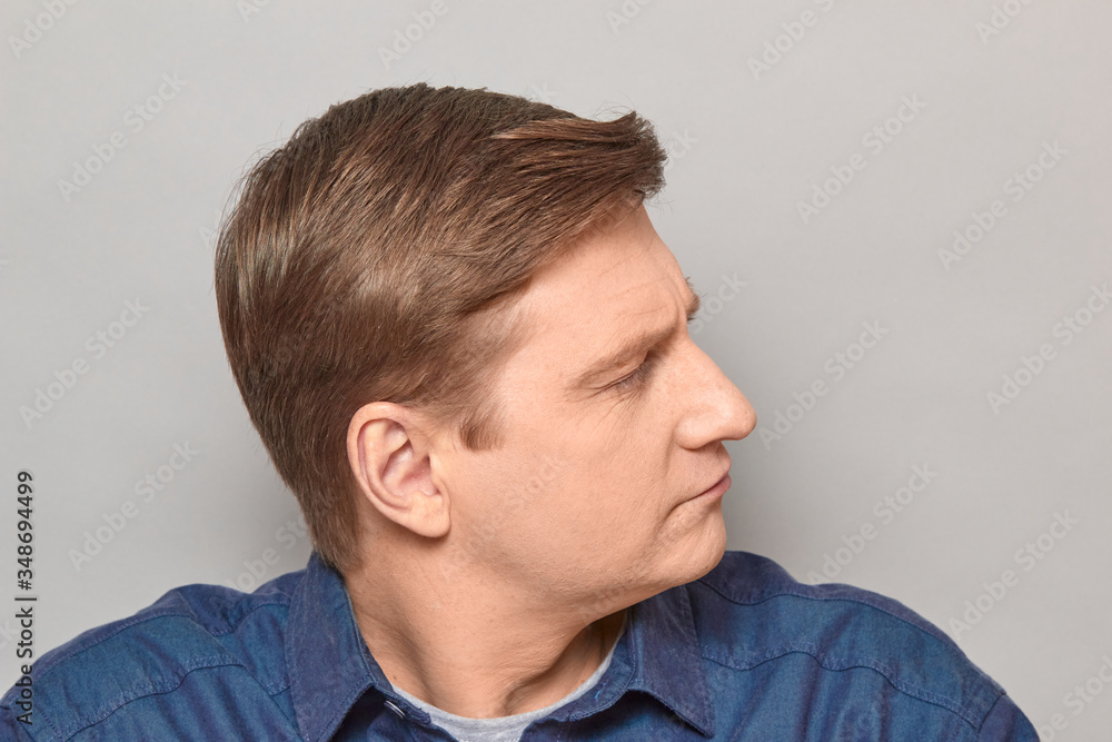 Obraz premium Portrait of confident focused blond mature man smiling slightly