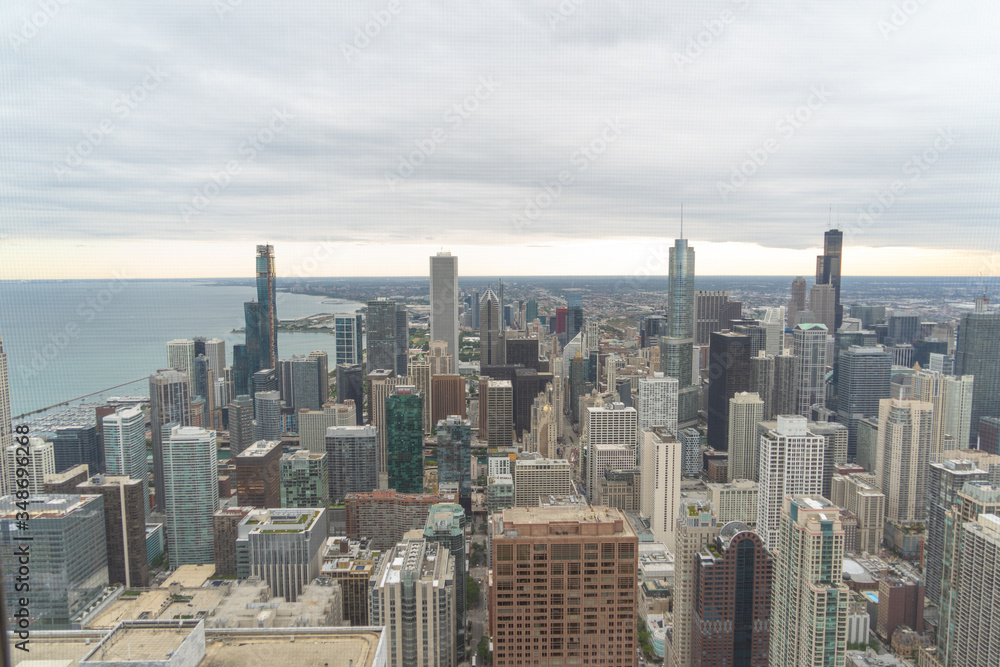 aerial view of chicago, showing some of the tallest buildings in the city. You can also see the lake and in the background you can see the sunset