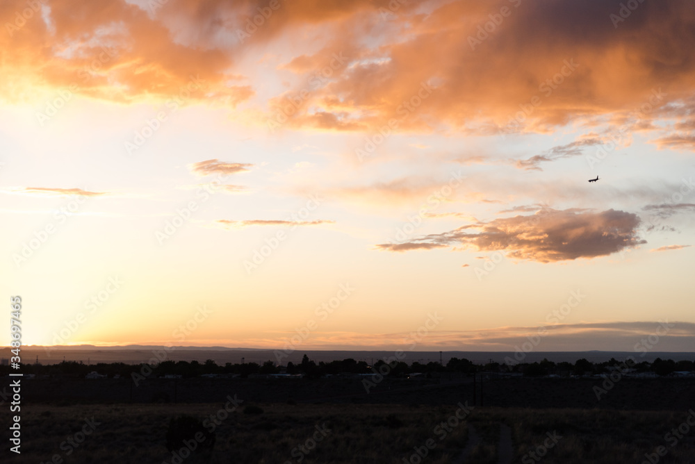 An airplane flying close to the ground during a sunset. 