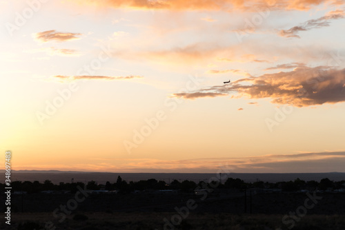 An airplane flying close to the ground during a sunset. 