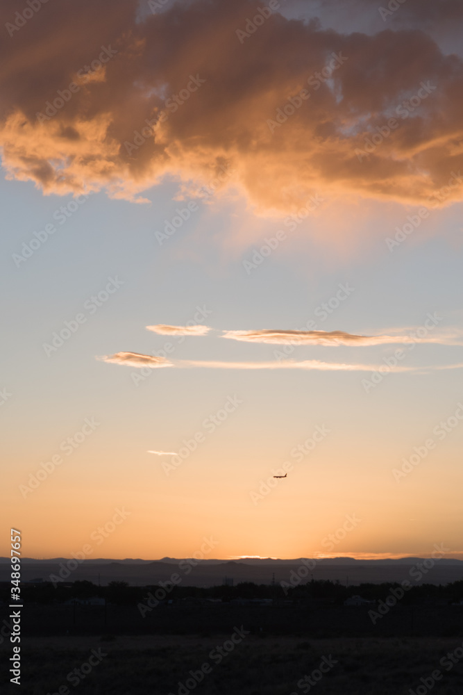 An airplane flying close to the ground during a sunset. 