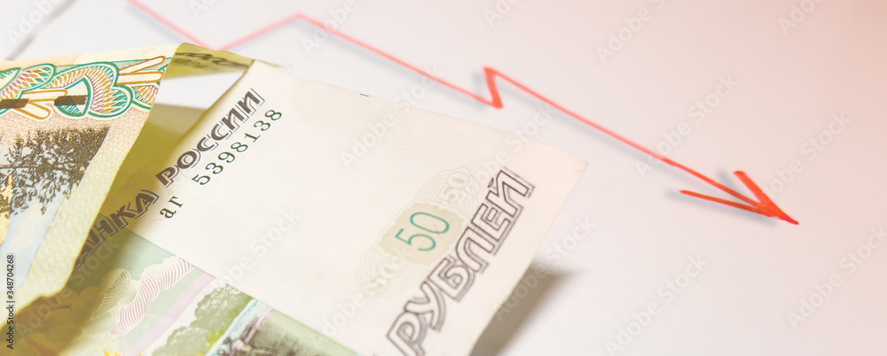 Russian currency and regressive chart. A bill of fifty Russian rubles and a red graph with an arrow. The concept of the Fall in the price of the Russian ruble, falling oil prices. Russian currency and regressive chart. A bill of fifty Russian rubles and a red graph with an arrow. The concept of the Fall in the price of the Russian ruble, falling oil prices.