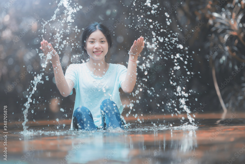 Fototapeta premium Young girl playing water stream