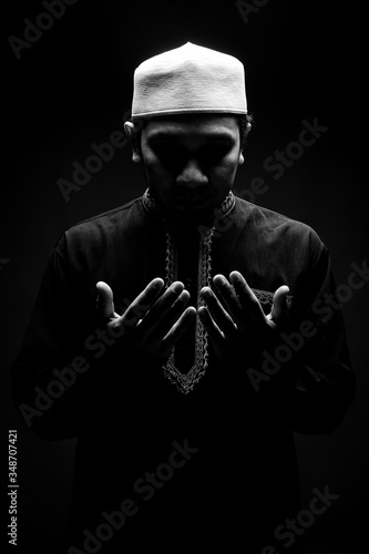Photography Portrait A good looking middle-aged Asian muslim man is praying for prayer with faith and determination