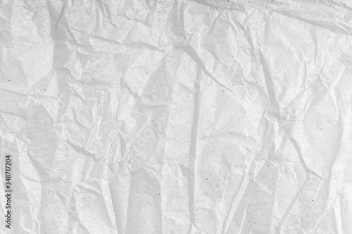 White wrinkled creased paper texture. Blank crumpled grainy paper textured surface. .