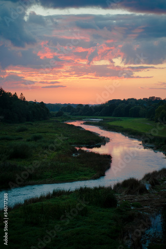 Beautiful sunset over a river with green bushes