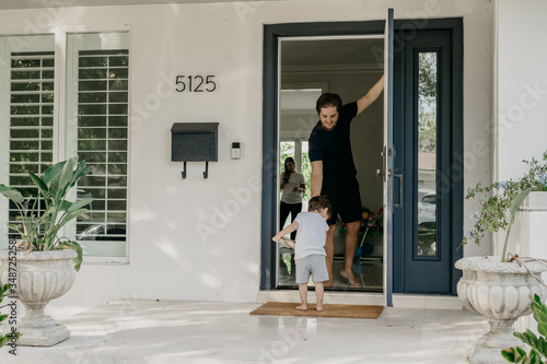 Young man in front of a door with toddler photo