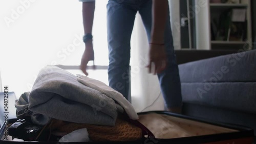 Travel woman unpacking suitcase in hotel room