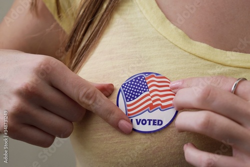 Woman applying a sticker after voting