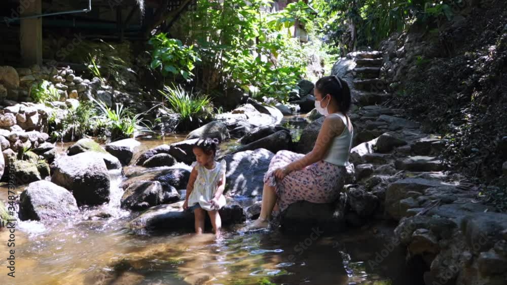 Mother and daughter sitting at nature stream. Mother and daughter sitting at nature stream.