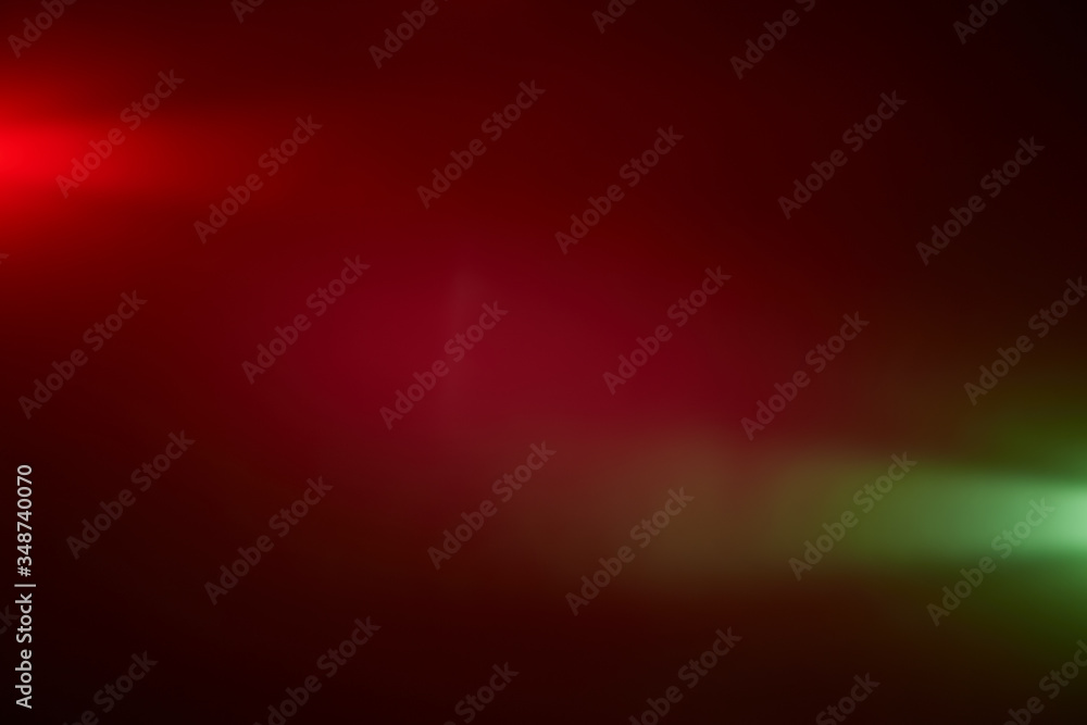On a dark red background, piercing rays of light red and light green On a dark red background, piercing rays of light red and light green