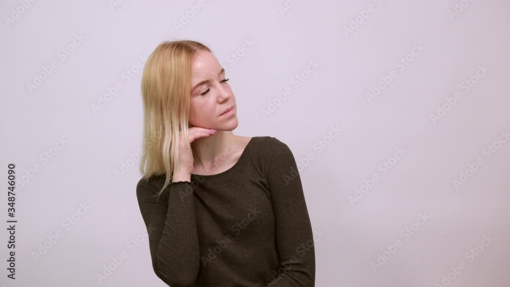 Young Blonde Woman In Black Sweater On White Background, Dreamy Girl Touches Her Chin And Thinks. The Concept Of Smart People, Intellectuals, Elite Of Society Young Blonde Woman In Black Sweater On White Background, Dreamy Girl Touches Her Chin And Thinks. The Concept Of Smart People, Intellectuals, Elite Of Society