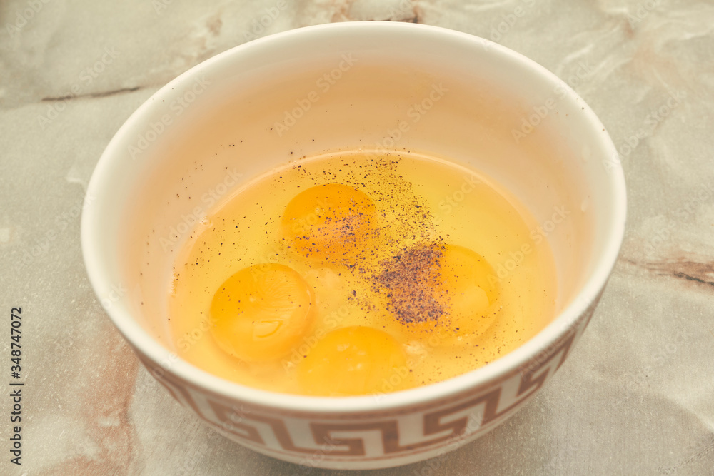 development of eggs in a plate with pepper four pieces of yolk on a marble table development of eggs in a plate with pepper four pieces of yolk on a marble table