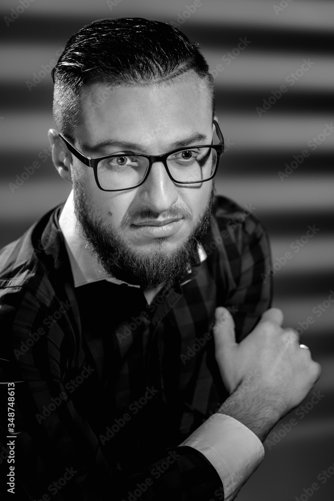 Portrait of young handsome smart man correcting glasses. image in black and white conversion Portrait of young handsome smart man correcting glasses. image in black and white conversion