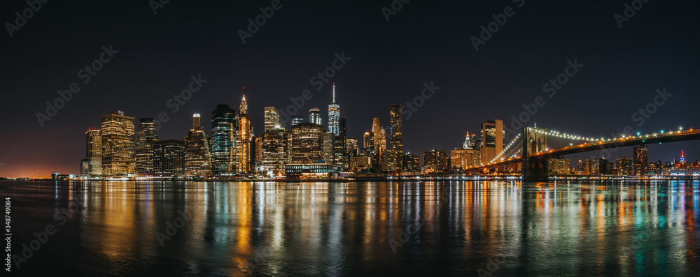 Panoramic view of Manhattan Bridge and Lower Manhattan Financial Disctrict at night with long exposure