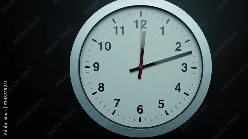 Close up Move the camera angle from right to left, Gray wall clock Twelve o'clock on black background, Time lapse 60 minutes moving fast, Time concept. Close up Move the camera angle from right to left, Gray wall clock Twelve o'clock on black background, Time lapse 60 minutes moving fast, Time concept.
