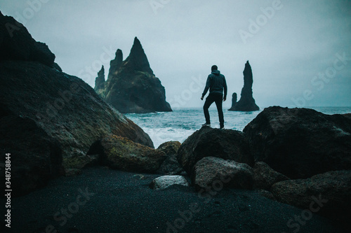 man on the rocks at sunset, dark mood photo, Iceland