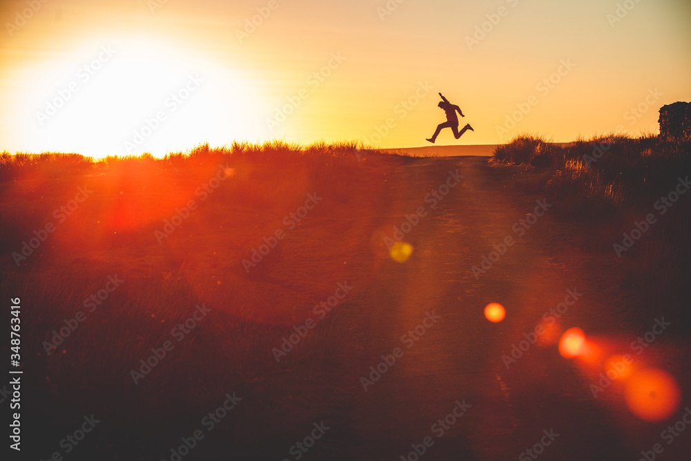 silhouette of a man running and jumping in the sunset