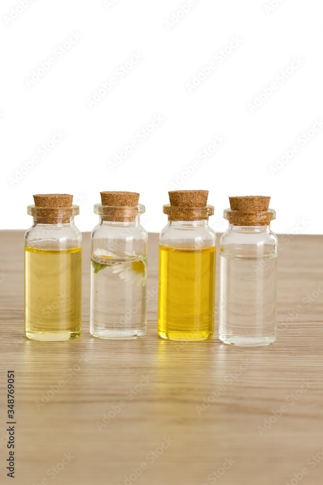 Transparent bottles of almond oil, jojoba oil and rose water for the production of natural environmentally friendly home cosmetics Transparent bottles of almond oil, jojoba oil and rose water for the production of natural environmentally friendly home cosmetics