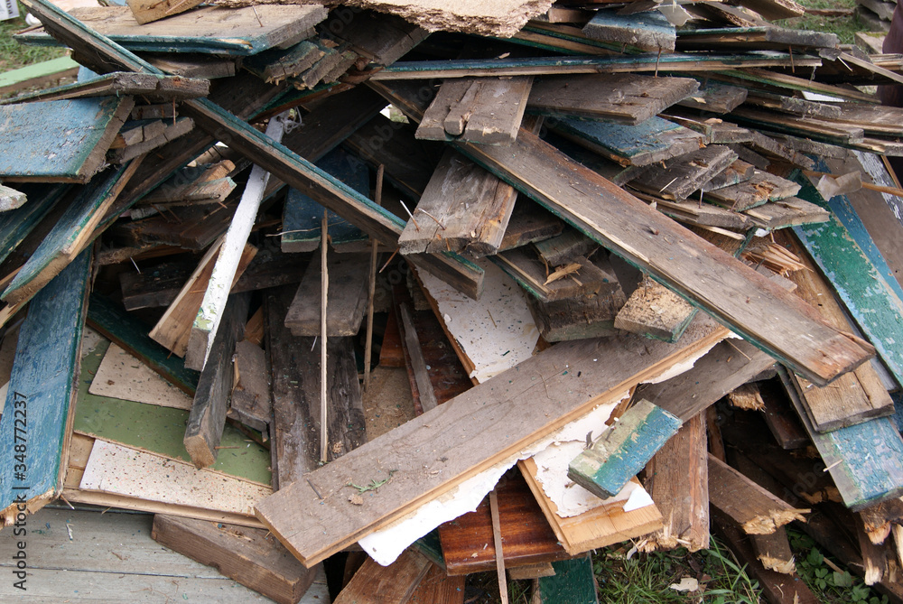 A pile of old boards with paint residue and nails sticking out
A pile of old boards with paint residue and nails sticking out