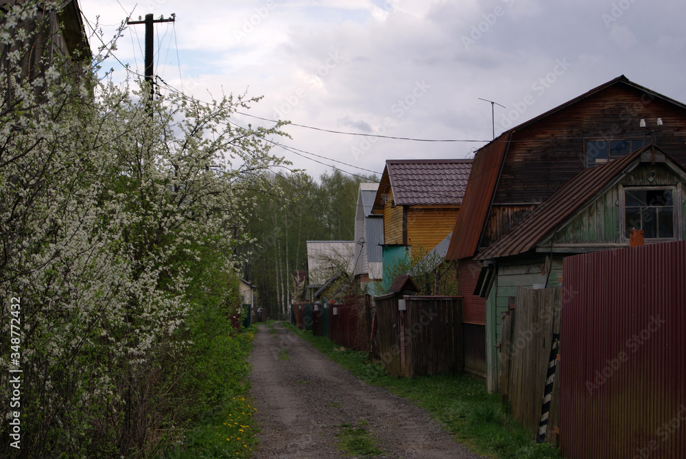 Street in the horticultural Association. Country houses behind high fences. A cloudy spring day. Street in the horticultural Association. Country houses behind high fences. A cloudy spring day.