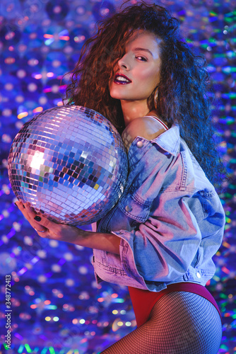 Young beautiful girl with long curly hair in ultraviolet light.