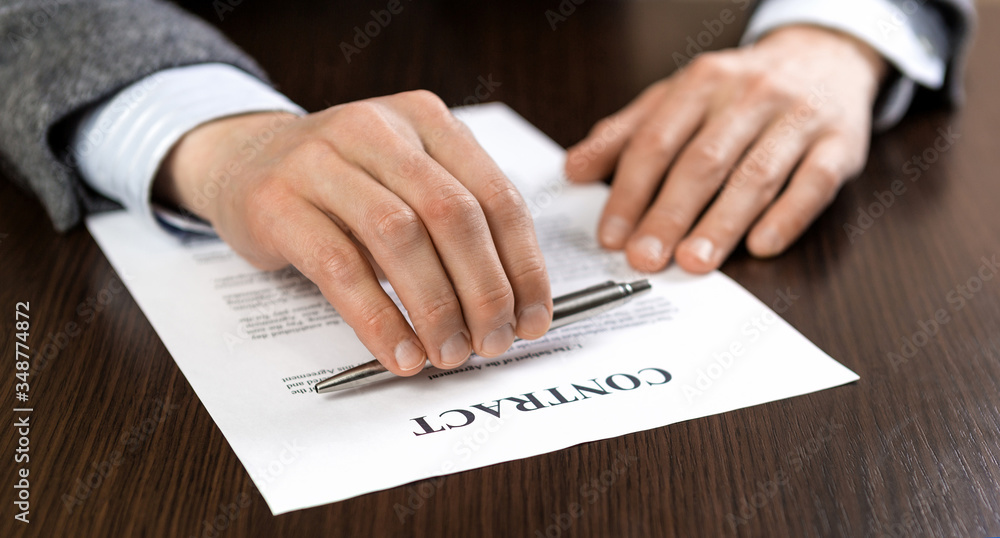portrait of businessman in suit reading contract documents at the desk in the office. portrait of businessman in suit reading contract documents at the desk in the office.