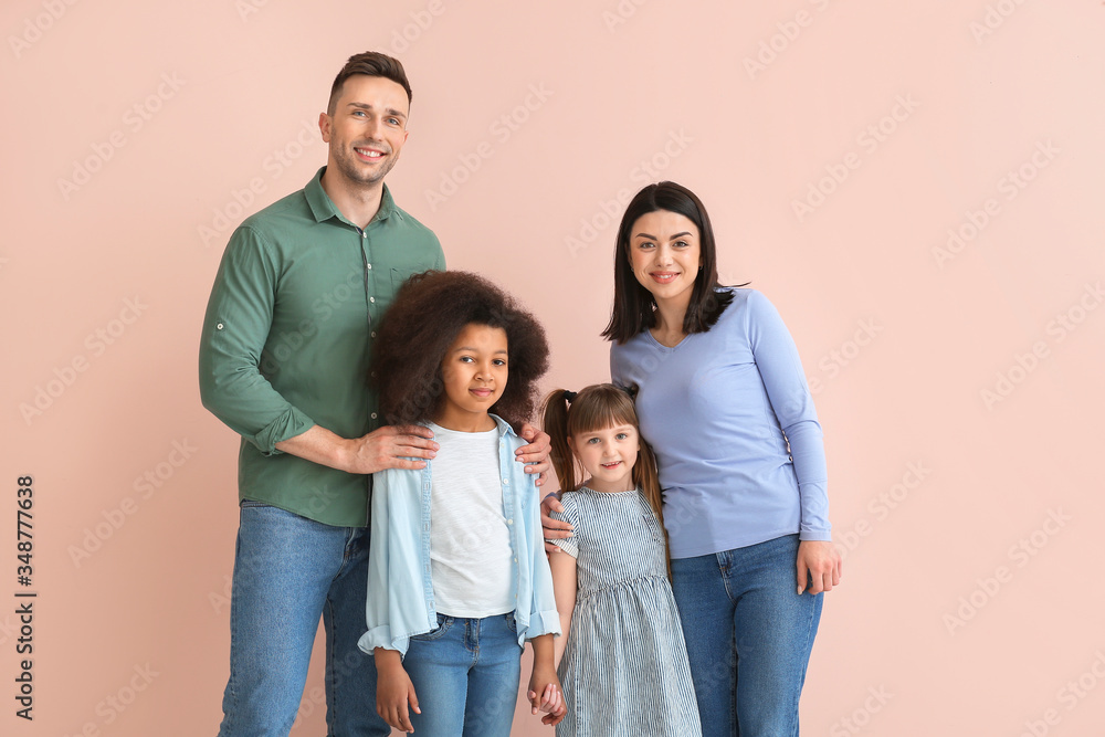 Happy couple with little adopted children on color background Happy couple with little adopted children on color background