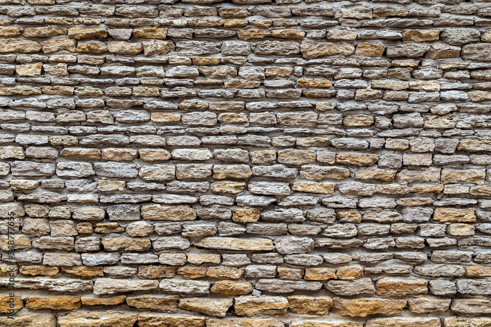 Fototapeta premium Stone wall texture background of stones stick together with clay.