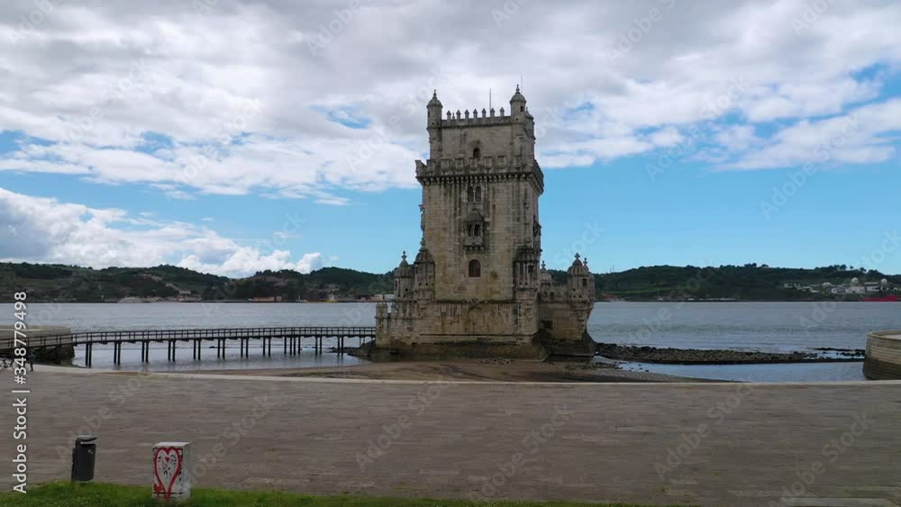Aerial, tracking, drone shot in front of the empty Torre de Belem tower, partly sunby day, in Lisbon, Portugal Aerial, tracking, drone shot in front of the empty Torre de Belem tower, partly sunby day, in Lisbon, Portugal
