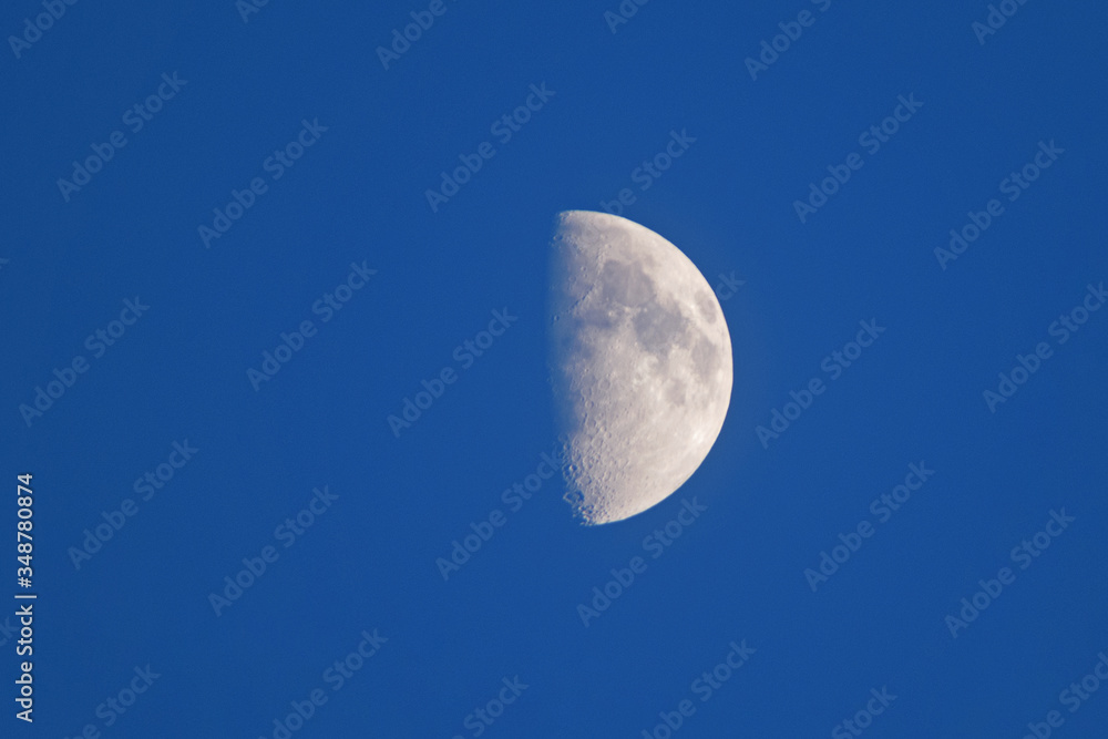 The surface of the moon is illuminated by the rays of the sun at sunset The surface of the moon is illuminated by the rays of the sun at sunset