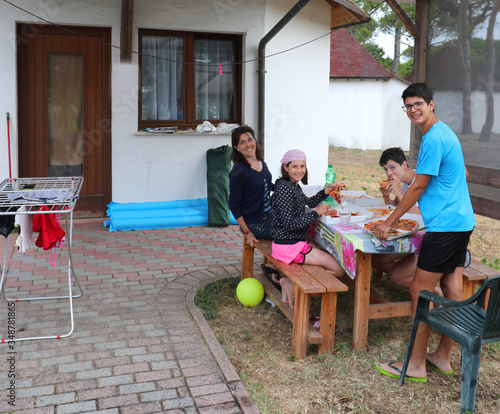 Happy family of four while eating pizza photo