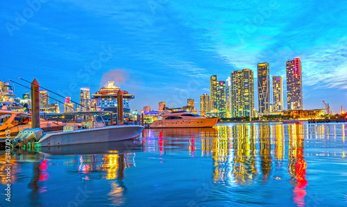 Miami city skyline panorama with urban skyscrapers over sea with reflection.