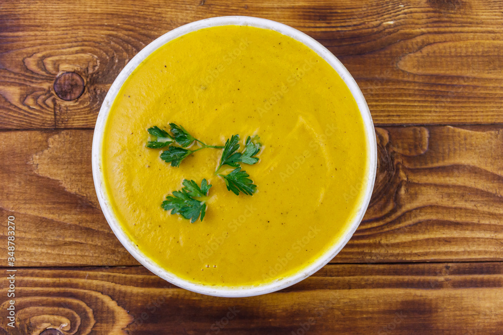 Pumpkin soup on a wooden table. Top view Pumpkin soup on a wooden table. Top view