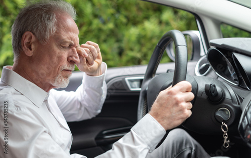 Φωτογραφία Tired man rubbing his eyes in car