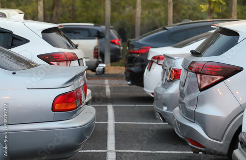 Closeup of back, rear side of soft blue cars parking in the opposite side in outdoor parking area. © Amphon