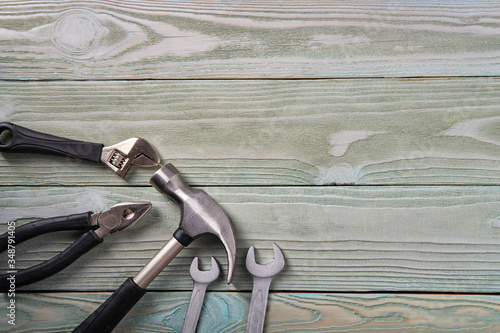 Metal hammer, pliers, keys on a wooden table