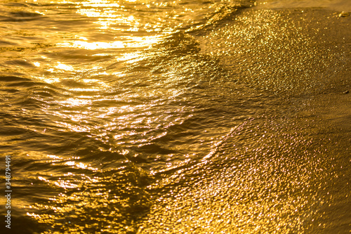 Water on the sandy shore at sunset. © schankz